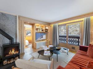 a living room with a couch and a fireplace at Appartement rénové avec 2 suites, balcon et poêle à bois, proche centre et remontées mécaniques, Megève - FR-1-569-39 in Megève