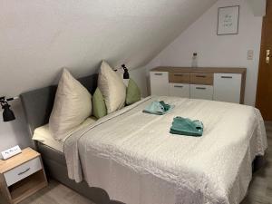 1 dormitorio con 1 cama y 2 toallas verdes en Wohlfuehl-Wohnung-im-Herzen-von-Clausthal, en Clausthal-Zellerfeld