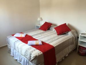 Un dormitorio con una cama grande con almohadas rojas. en Estudio San Lorenzo en San Miguel de Tucumán