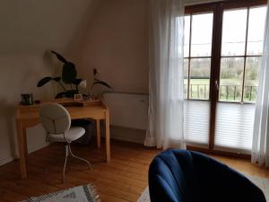 ヴェーゼルにあるFerienwohnung Niederrheinの窓付きの客室で、デスクと椅子が備わります。