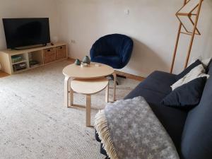 sala de estar con sofá, mesa y TV en Ferienwohnung Niederrhein, en Wesel