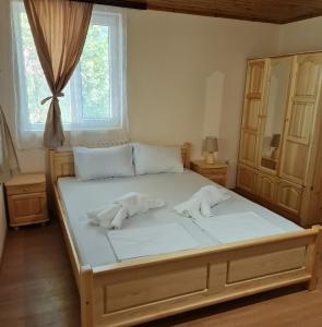 een slaapkamer met een bed met 2 kussens erop bij Вила Вайлин in Batak