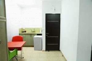 une cuisine avec une porte noire et une chaise rouge dans l'établissement Aseel hostel, à Majdal Shams