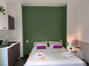 1 dormitorio con 1 cama grande y pared verde en Bnbook Residence Matteotti, en Novara