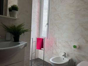 Baño blanco con lavabo y aseo en Bnbook Residence Matteotti, en Novara