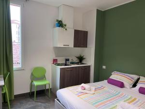 Habitación pequeña con cama y pared verde en Bnbook Residence Matteotti, en Novara