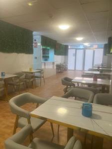 un comedor con mesas y sillas en una cafetería en Limin Hostel Capsules en Valencia