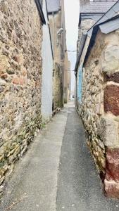 a narrow alley with a stone building and a street at La p'tite sardine in Camaret-sur-Mer