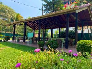 a pavilion with tables and chairs in a garden at Hotel TK Green Garden in Matara