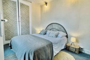 a bedroom with a bed with blue sheets and pillows at La p'tite sardine in Camaret-sur-Mer