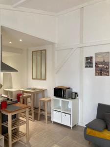 a kitchen and living room with a table and a microwave at Studio Chez Bob in Montreuil