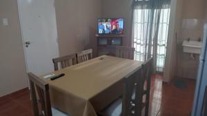 comedor con mesa, sillas y TV en Departamento "MI SUEÑO" en San Juan