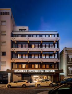 two cars parked in front of a building at Empire Marquês Hotel in Lisbon