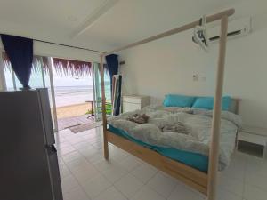 a bedroom with a bed and a view of the beach at Tiongman Scubadive & Lodge in Tioman Island