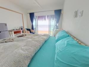 a bedroom with a bed with a view of the beach at Tiongman Scubadive & Lodge in Tioman Island
