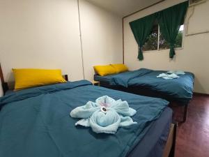 two beds in a room with towels on them at Tiongman Scubadive & Lodge in Tioman Island