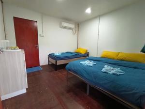 a room with two beds with towels on them at Tiongman Scubadive & Lodge in Tioman Island