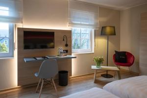 a hotel room with a bed and a desk at Der Stahlberg Hotel & Restaurant in Hilchenbach