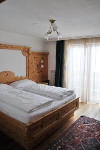 a bedroom with a wooden bed and a window at Bilocale Campo in Madonna di Campiglio