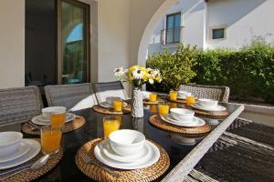 una mesa con platos, tazones y vasos de zumo de naranja en Villa Ingrid, en Ayia Napa