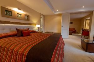 um quarto de hotel com uma cama e uma sala de estar em Fueguino Hotel em Ushuaia