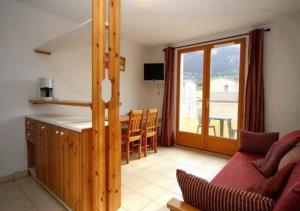 cocina y sala de estar con sofá y mesa en Olydea Montbrun-les-Bains, en Montbrun-les-Bains