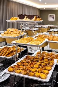 a display of trays of pastries and donuts on tables at Empire Marquês Hotel in Lisbon