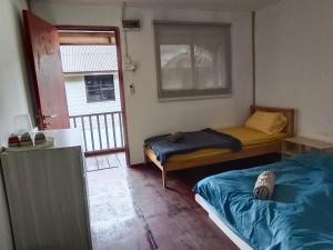 a small room with two beds and a window at Tiongman Scubadive & Lodge in Tioman Island