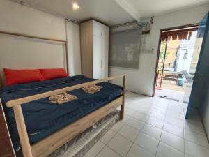 a bedroom with a bed with a blue comforter at Tiongman Scubadive & Lodge in Tioman Island