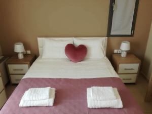 a bedroom with a bed with a heart pillow on it at VISTA DI MARE 3 in Lixouri
