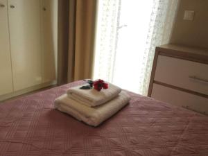 a stack of towels on a bed with a window at VISTA DI MARE 3 in Lixouri