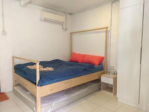 a small bedroom with a bed with blue sheets and red pillows at Tiongman Scubadive & Lodge in Tioman Island