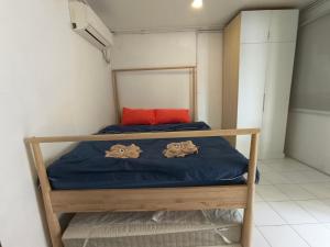 a small bedroom with a bed with blue sheets and a red pillow at Tiongman Scubadive & Lodge in Tioman Island