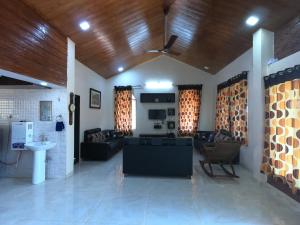 a living room with a couch and a ceiling fan at Sai Leela Bungalow - Villa with Private Pool in Mahabaleshwar