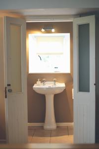 baño con lavabo y ventana en Scott's Barn en Cookstown