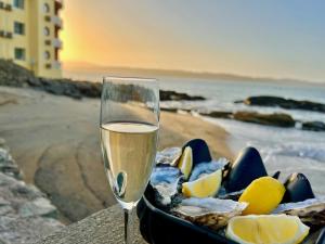 Lüderitz Nest Hotel في لودريتز: كأس من الشمبانيا بجانب وعاء من الطعام
