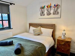 a bedroom with a bed and two paintings on the wall at Central, Unique 4-Storey House in Northern Quarter, Manchester in Manchester