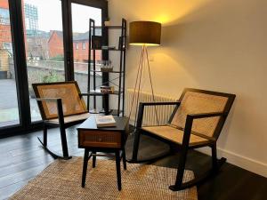 a living room with two chairs and a table and a lamp at Central, Unique 4-Storey House in Northern Quarter, Manchester in Manchester