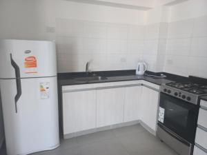 uma pequena cozinha com um frigorífico e um lavatório em Departamento centrico em Salta