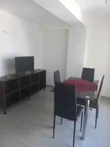 comedor con mesa, sillas y TV en Departamento centrico en Salta