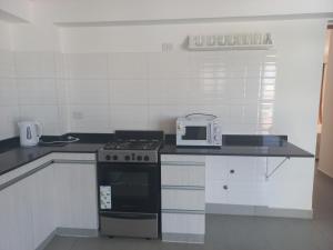 uma cozinha com um fogão e um micro-ondas em Departamento centrico em Salta