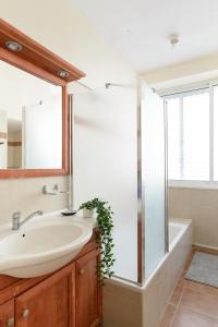 a bathroom with a sink and a mirror and a tub at Gordon Seaside 4BDR apt in TLV in Tel Aviv