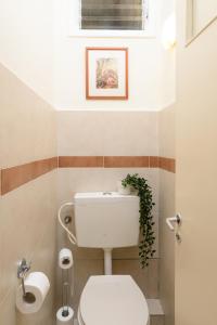 a bathroom with a white toilet with a plant on it at Gordon Seaside 4BDR apt in TLV in Tel Aviv