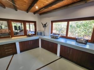 een grote keuken met blauwe aanrechtbladen en ramen bij Milkwood Safari Lodge in Warmbaths