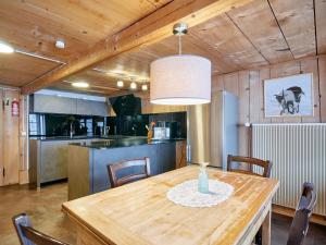 a kitchen with a wooden table with a vase on it at Gästehaus Hof Maiezyt in Habkern