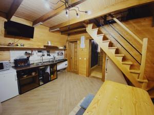 a kitchen with a wooden staircase in a cabin at Sadyba Lileya in Verkhovyna