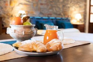 un tavolo con un piatto di pane e una brocca di succo d'arancia di B&B Al Castello a Casale Litta