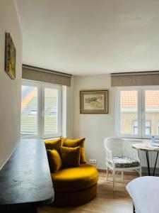 a living room with a yellow couch and a table at Belle de Jour B&B in Ostend