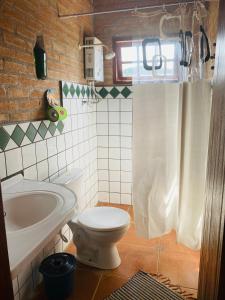 een badkamer met een toilet, een bad en een wastafel bij Chalé buraco do tatu in Conceição da Ibitipoca