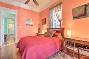 1 dormitorio con paredes de color naranja, 1 cama y escritorio en New Orleans Vacation Rental with Private Patio!, en Nueva Orleans